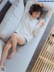 A woman laying on a couch reading a book.