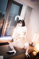 A woman in a bunny costume sitting on a window sill.